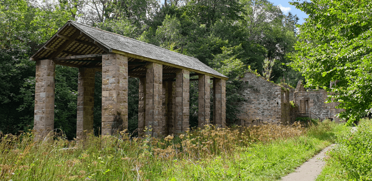 Howk Bobbin Mill: a historical stone building amongst leafy woodland